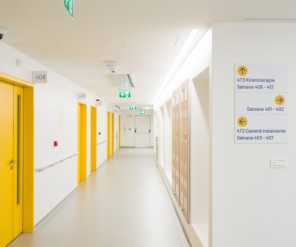 Señalización de emergencia en un pasillo de hospital.