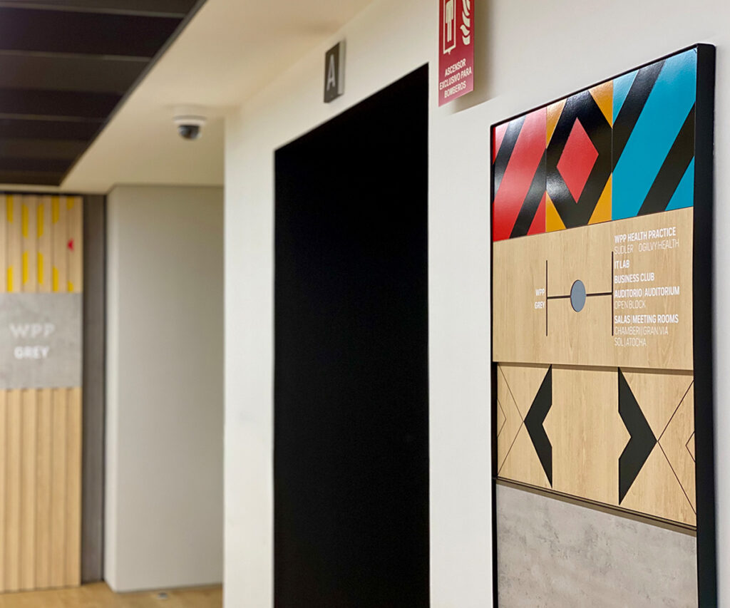 Panel de señalización que emula madera, cemento y cerámica. 